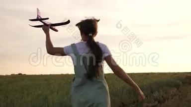 快乐女孩<strong>带着</strong>玩具飞机在麦田里奔跑。 孩子们玩玩具飞机。 少年<strong>梦想</strong>飞翔，成为一名